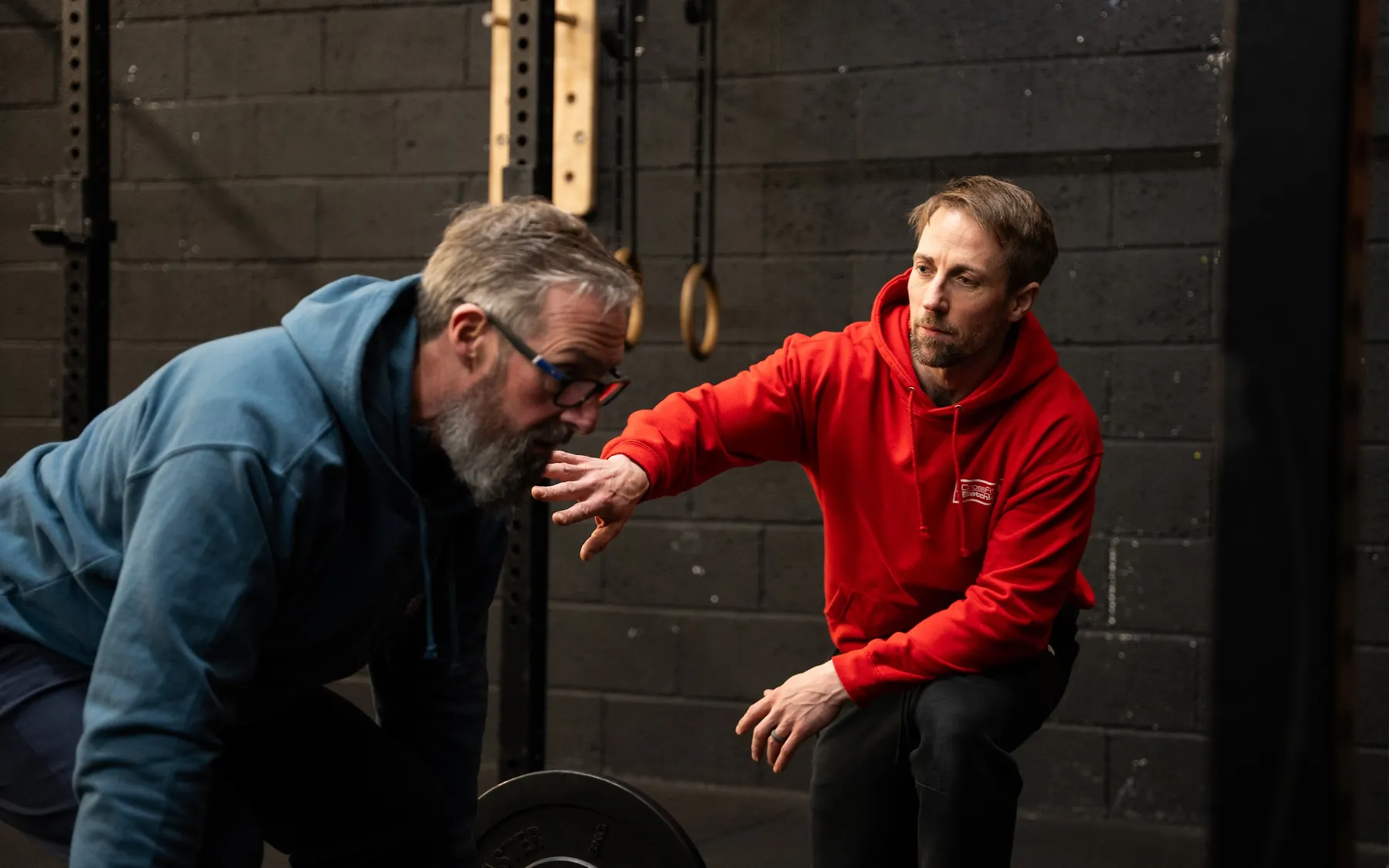 A coach talking a member through a deadlift set-up